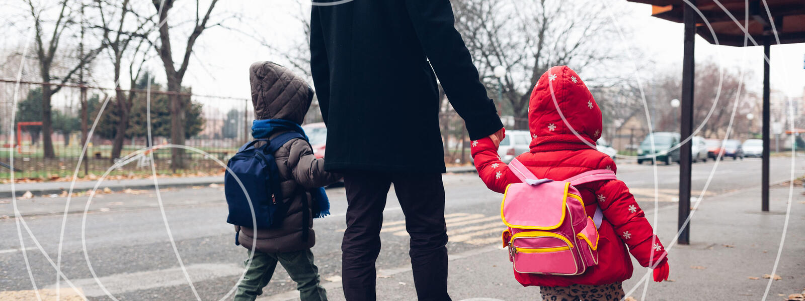 two children walking with parent, holding hands