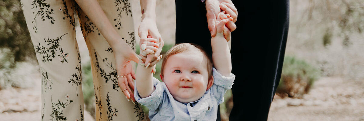 baby walking with parents
