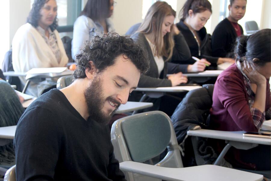 male graduate student in the forefront of students in a lecture room at northwestern