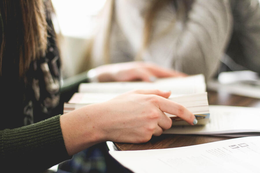 two hands hold a book, studying