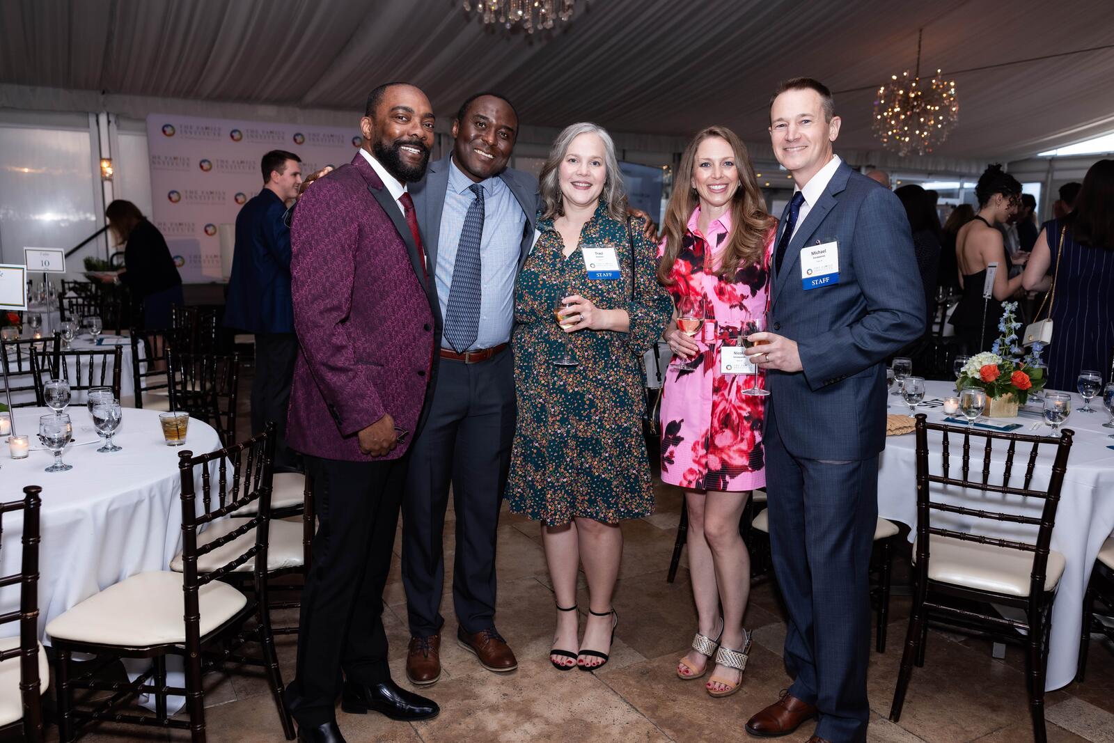 Staff of The Family Institute stand and smile in the dining room at the Gratitude Gala.